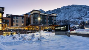 A Courtyard by Marriott hotel with a snow-covered landscape and mountains in the background. - Courtyard by Marriott Salt Lake City Cottonwood (Salt Lake City)