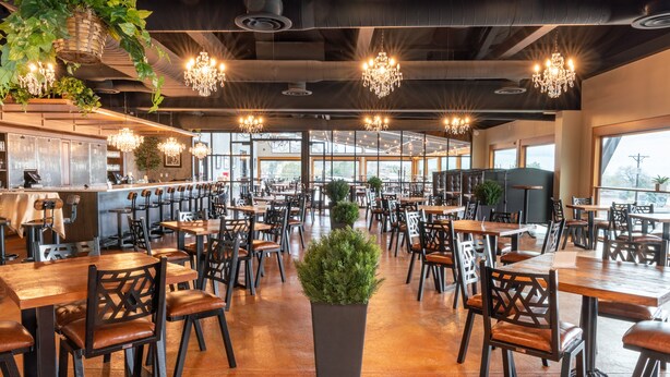 A spacious restaurant with high ceilings, chandeliers, and large windows. - Courtyard by Marriott Salt Lake City Cottonwood (Salt Lake City)