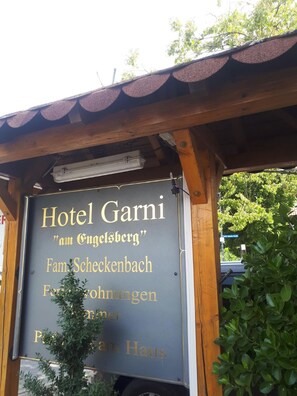 A sign for Hotel Garni with the address "am Engelsberg" and mentions amenities like a family room, sauna, and parking.