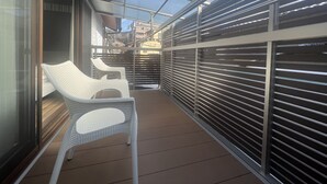A corridor with a glass ceiling, white wicker chairs, and metal railings. - Platinum Kiyomizu (Kyoto)