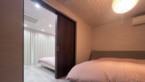 A modern bedroom with a large bed, a wooden wardrobe, and a ceiling light. - Platinum Kiyomizu (Kyoto)