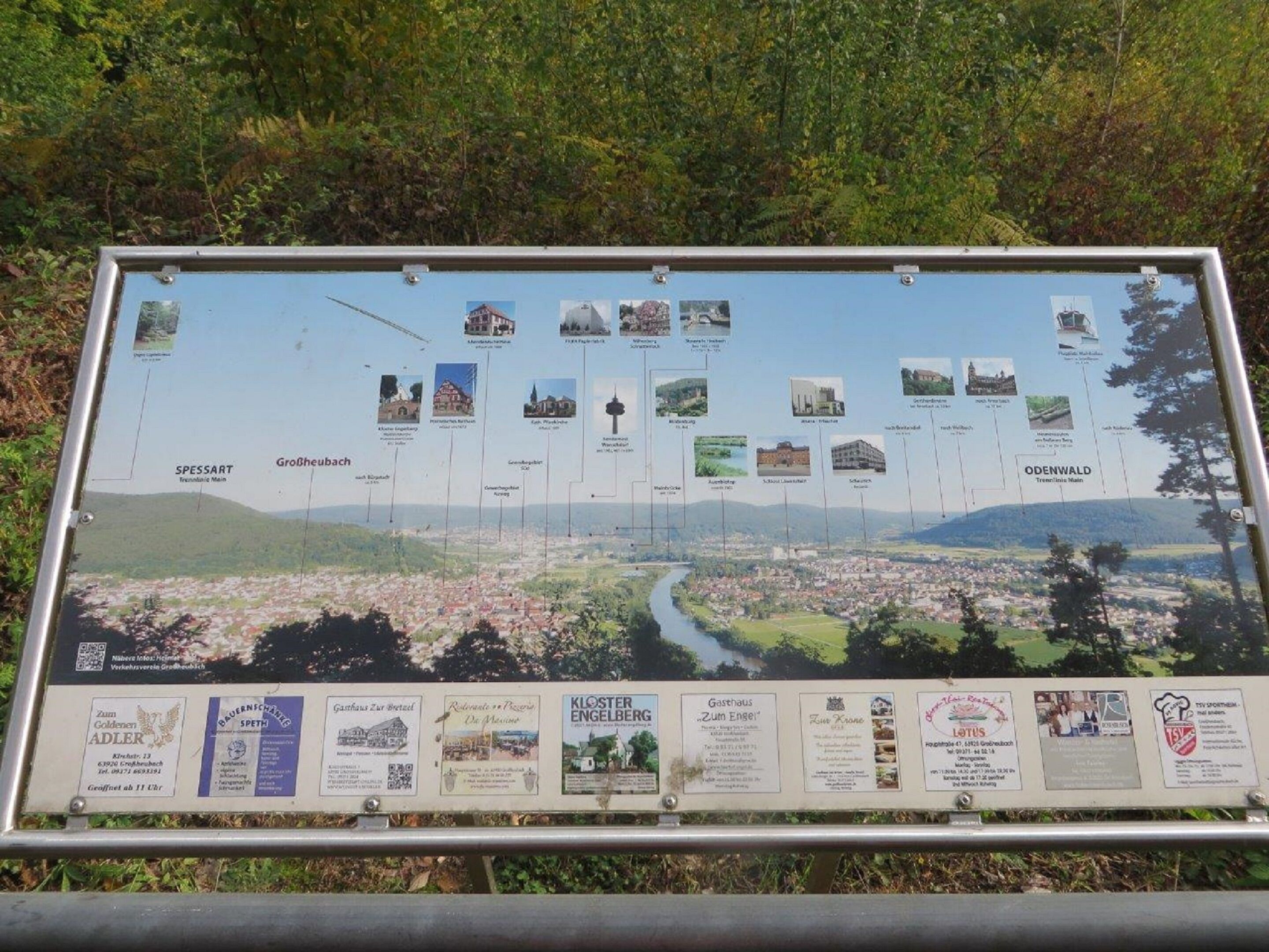 A tourist information board with a map and pictures of local attractions.