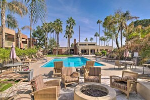 A pool area with lounge chairs, a fire pit, and palm trees. - Golfer's Haven! Condo w/ Pool Access in Scottsdale (Scottsdale)