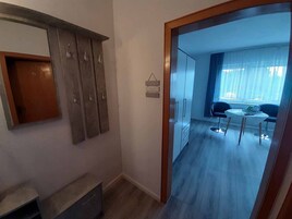 Habitación de hotel con un armario de madera, un escritorio pequeño y un área de comedor con mesa y sillas.