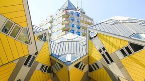 Edifício com projeto singular, fachada geométrica complexa e várias sacadas.