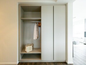 A walk-in closet with shelves and hanging space, a basket, and a door. - Hafenspitze App. 16 Pier 2.16 (Wismar)