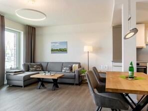 Un salon moderne comprenant un canapé, une table basse, une table à manger et une lampe.