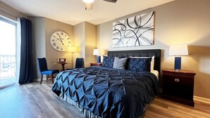 Ein modernes Hotelzimmer mit einem großen Bett, zwei Nachttischen, einer Wanduhr und einem großen Fenster mit Vorhängen.