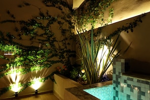 Indoor garden area with lush plants and a mosaic-tiled wall.