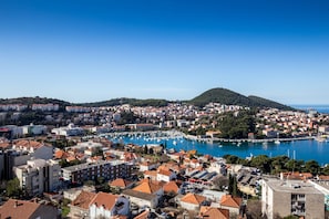 A coastal cityscape with a marina, dense urban buildings, and a hill in the background. - Apartment Brajkovic (Dubrovnik)