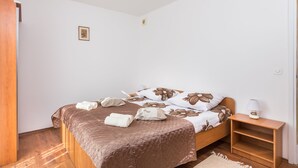 Ein Schlafzimmer mit einem hölzernen Bett, einem Nachttisch mit Lampe und einem kleinen Bild an der Wand.