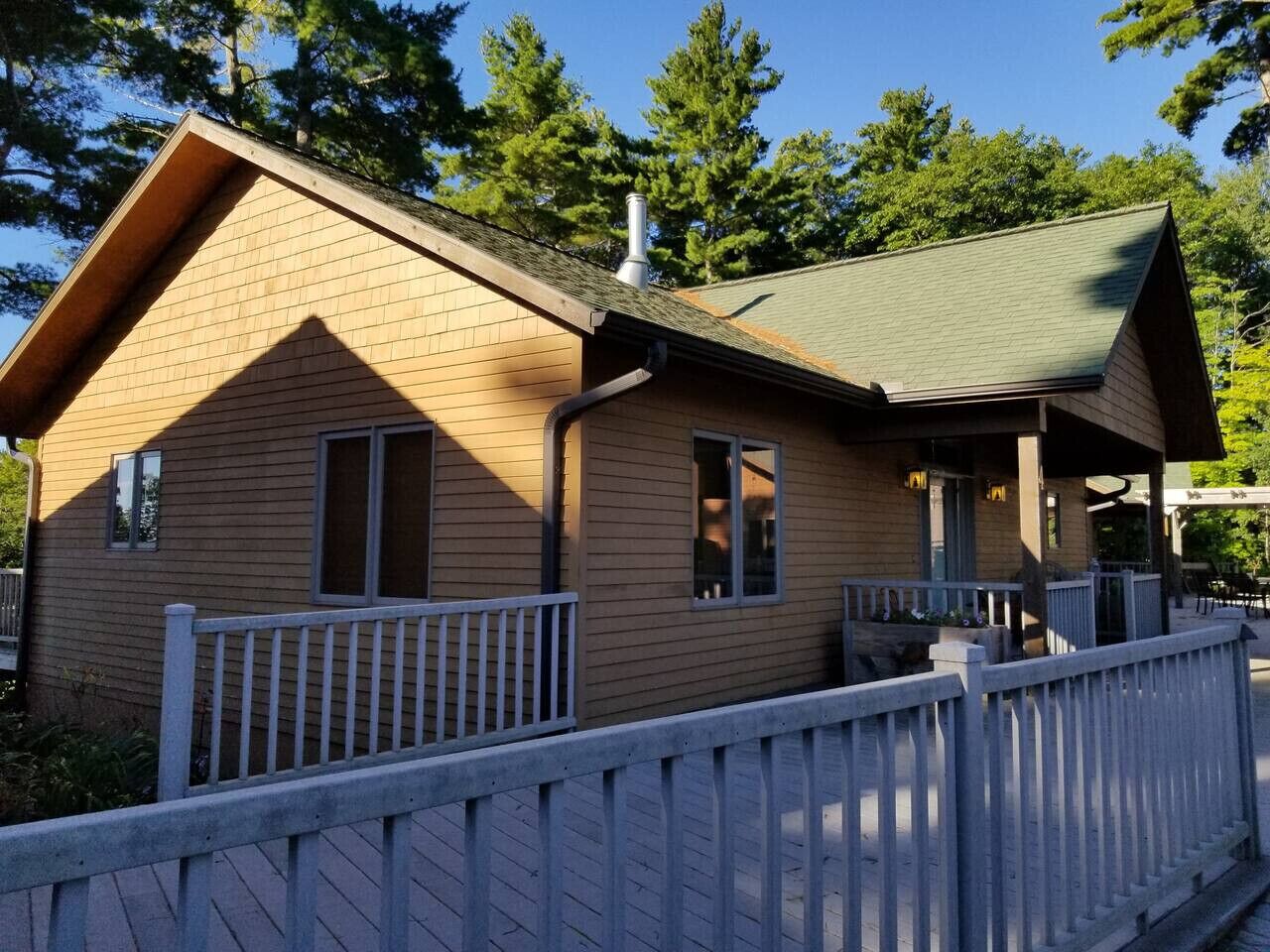 Eine Holzhütte mit Veranda und umzäunter Terrasse.