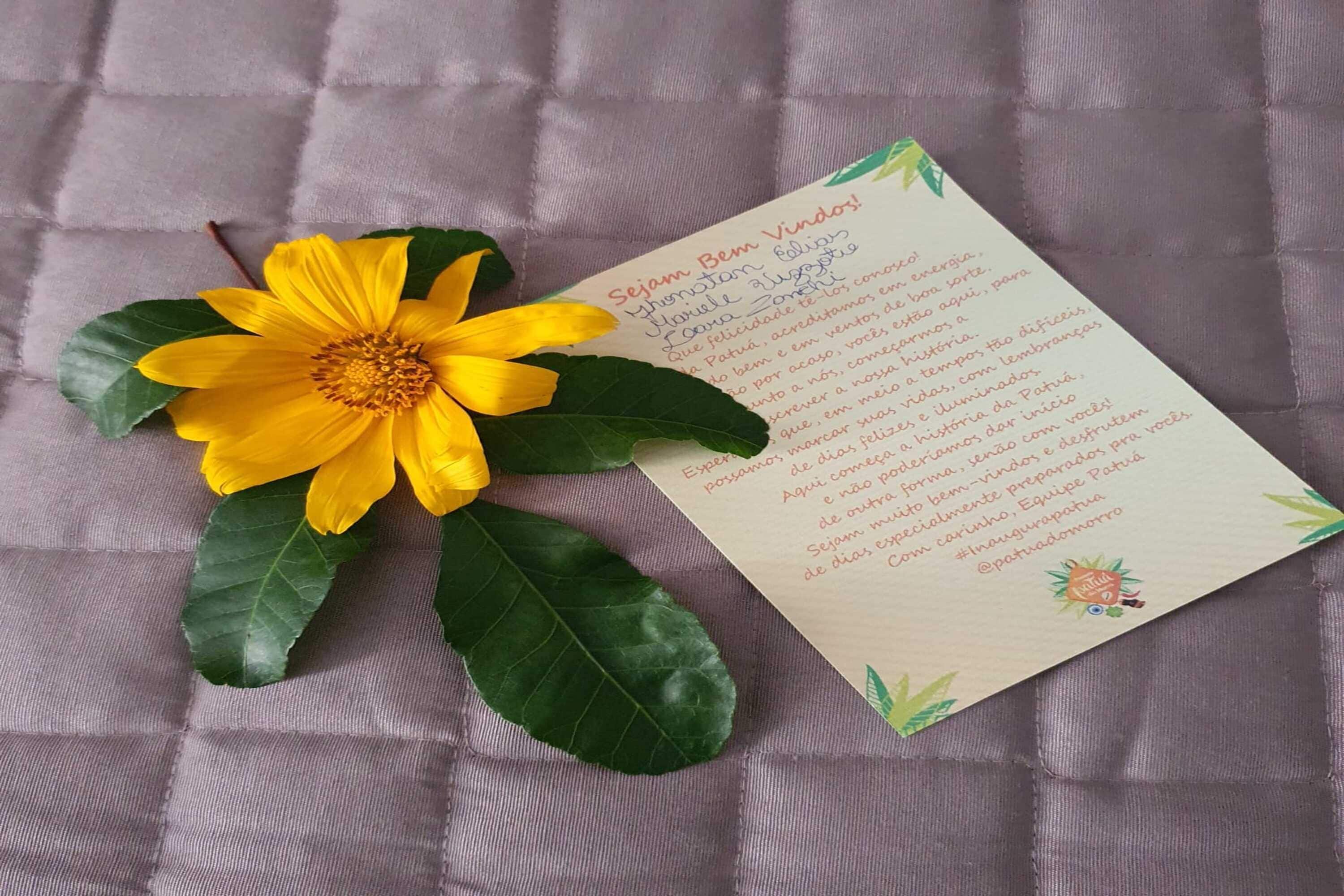 A card with text and a yellow flower on a textured surface.