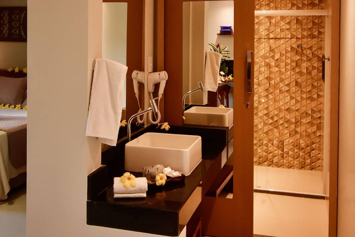 Une salle de bain moderne équipée d’un double lavabo, d’un sèche-cheveux et d’un miroir.