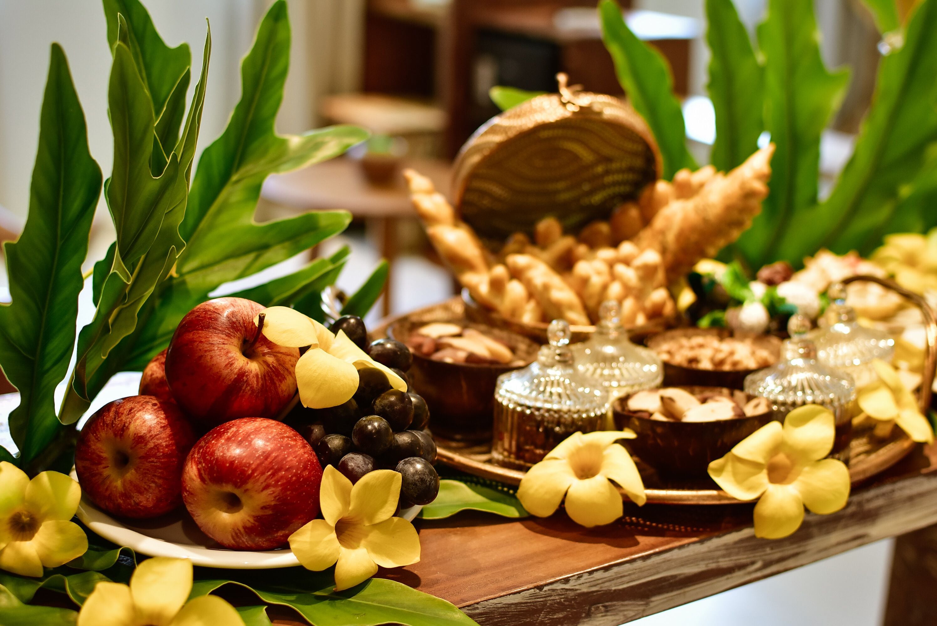 Una mesa con frutas, pan y adornos.