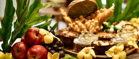 A table with fruits, bread, and decorative items.
