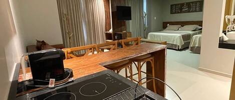 Cocina compacta con estufa, lavabo y comedor.
