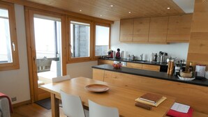 Une cuisine moderne avec des meubles de rangement en bois, une table à manger et des chaises.