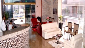 A hotel lobby with a reception desk, a white sofa, and several chairs. - Excel Oriental Hotel & Suites (Lagos)