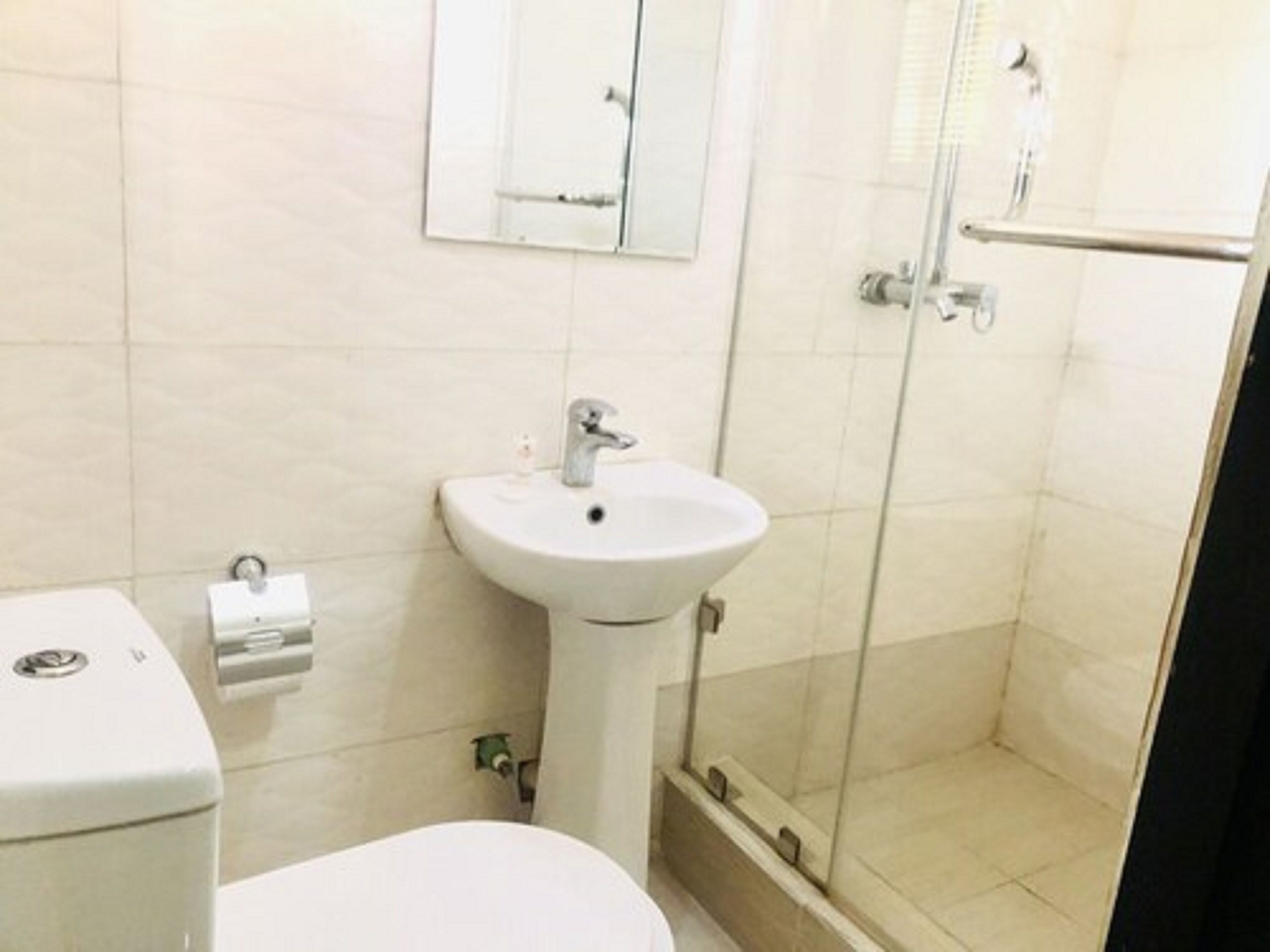 Et badeværelse med toilet, vask og bruser.