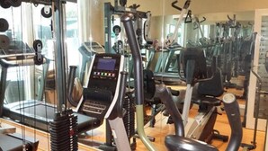 A gym with cardio machines, weight machines, and a mirrored wall. - Villa Angelia Hotel Annex (Lagos)