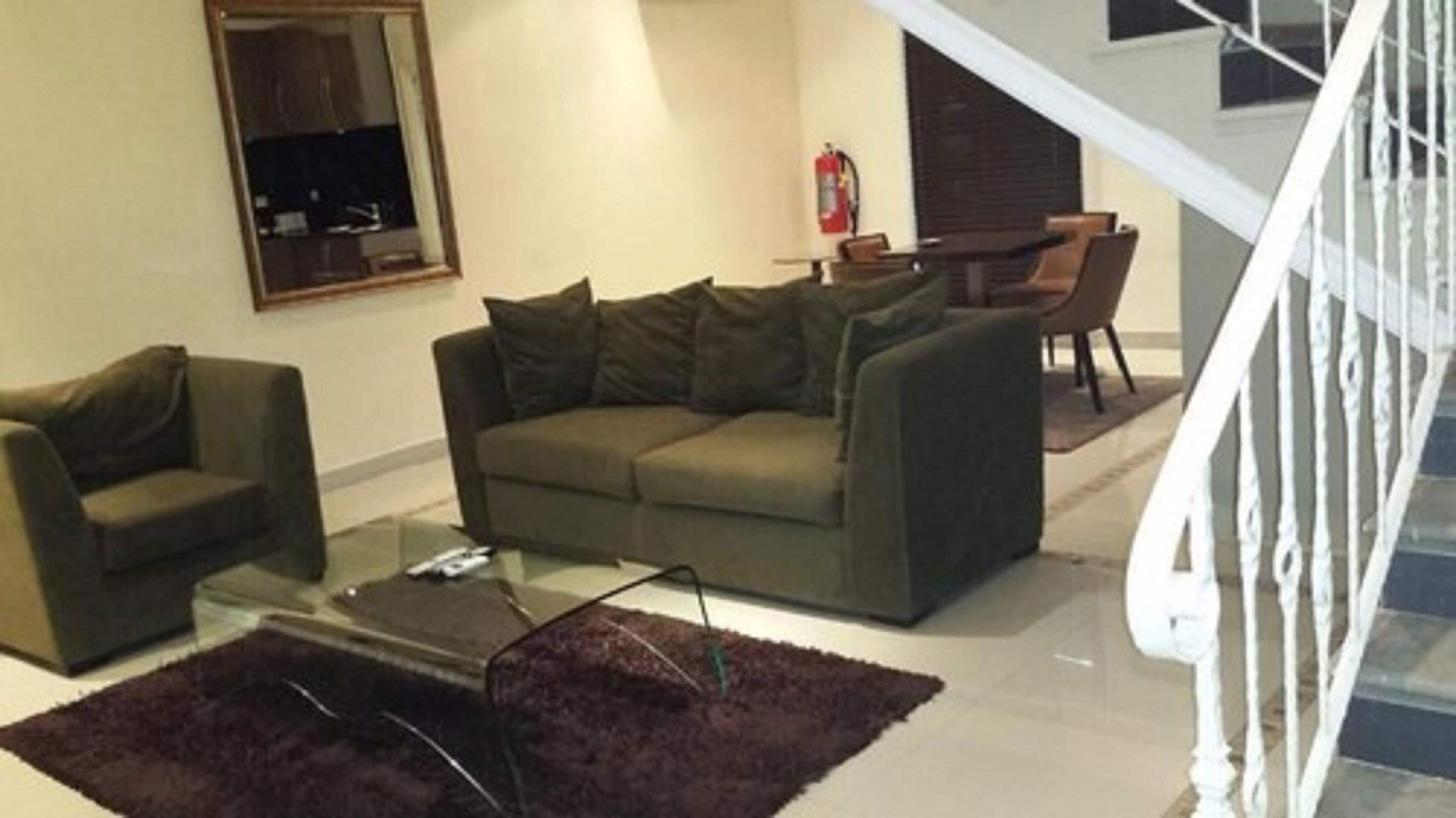 A living room with a sofa, a coffee table, and a fireplace.