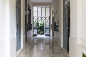 Un couloir avec une grande porte vitrée donnant sur un jardin.