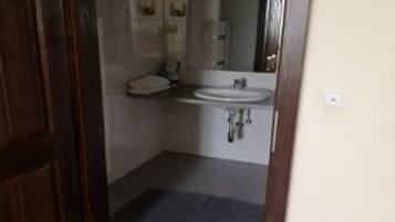 Un baño pequeño con inodoro, lavabo y espejo.
