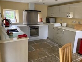 A kitchen with a stove, oven, microwave, and cabinets.