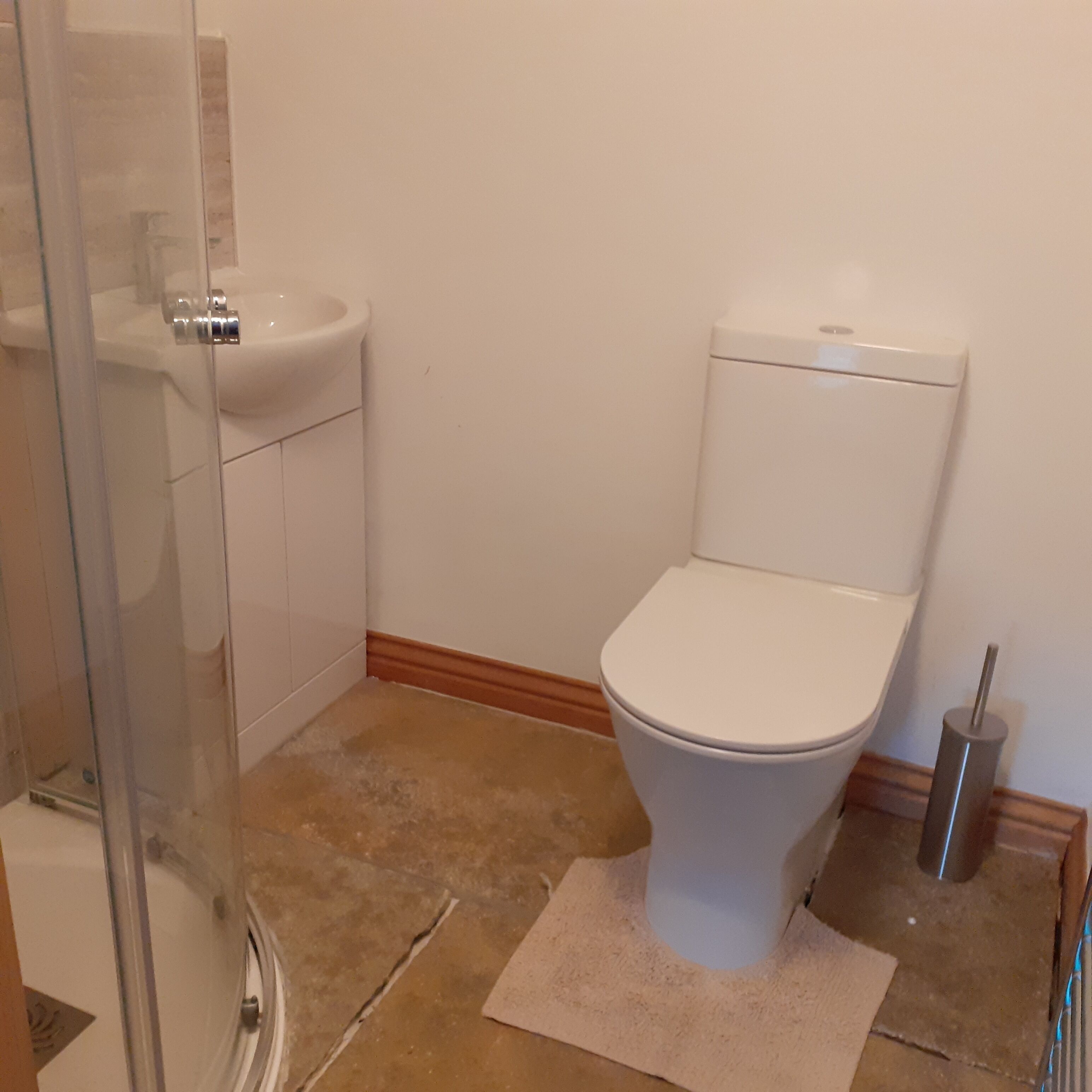 A bathroom with a toilet, sink, and shower.