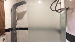 A bathroom with a glass-enclosed shower, a toilet, and a towel rack. - Six Diamond Hotel (Lagos)