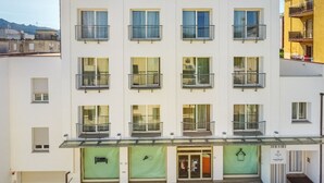 A multi-story hotel with a modern facade, balconies, and a ground-level entrance with glass doors. - Felix Hotels - Residence Grandi Magazzini (Nuoro)