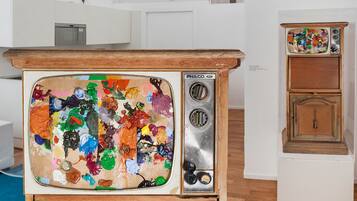 Una habitación con una cama litera, una radio antigua y un aparador de madera.