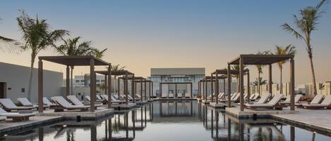 Een buitenzwembad en ligstoelen