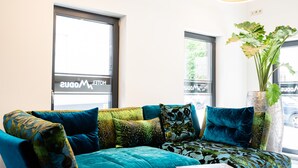 Una sala de estar moderna con un sofá seccional color turquesa, una mesa de centro y una planta en maceta.