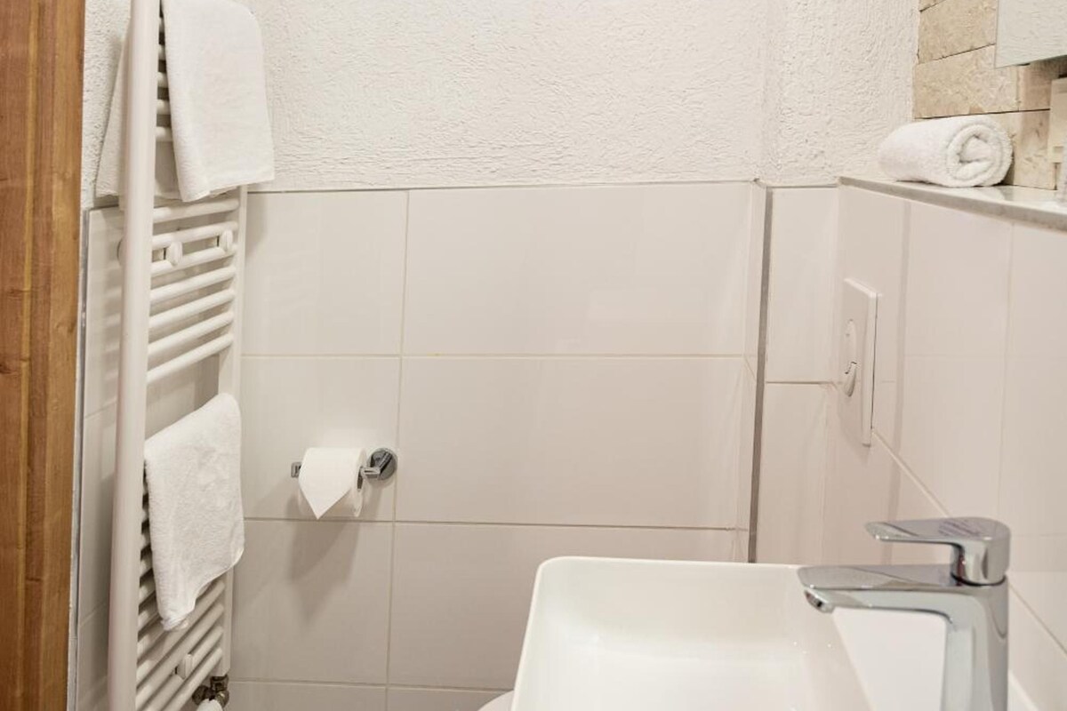A bathroom with a white sink, a towel rack, and a toilet.