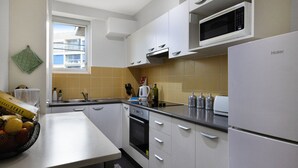 A modern kitchen with white cabinets, a built-in oven, a microwave, and a refrigerator. - BAYSIDE BLISS - PRIVATE & TRANQUIL WITH VIEWS, AIR CONDITIONING AND LIFT (Rushcutters Bay)