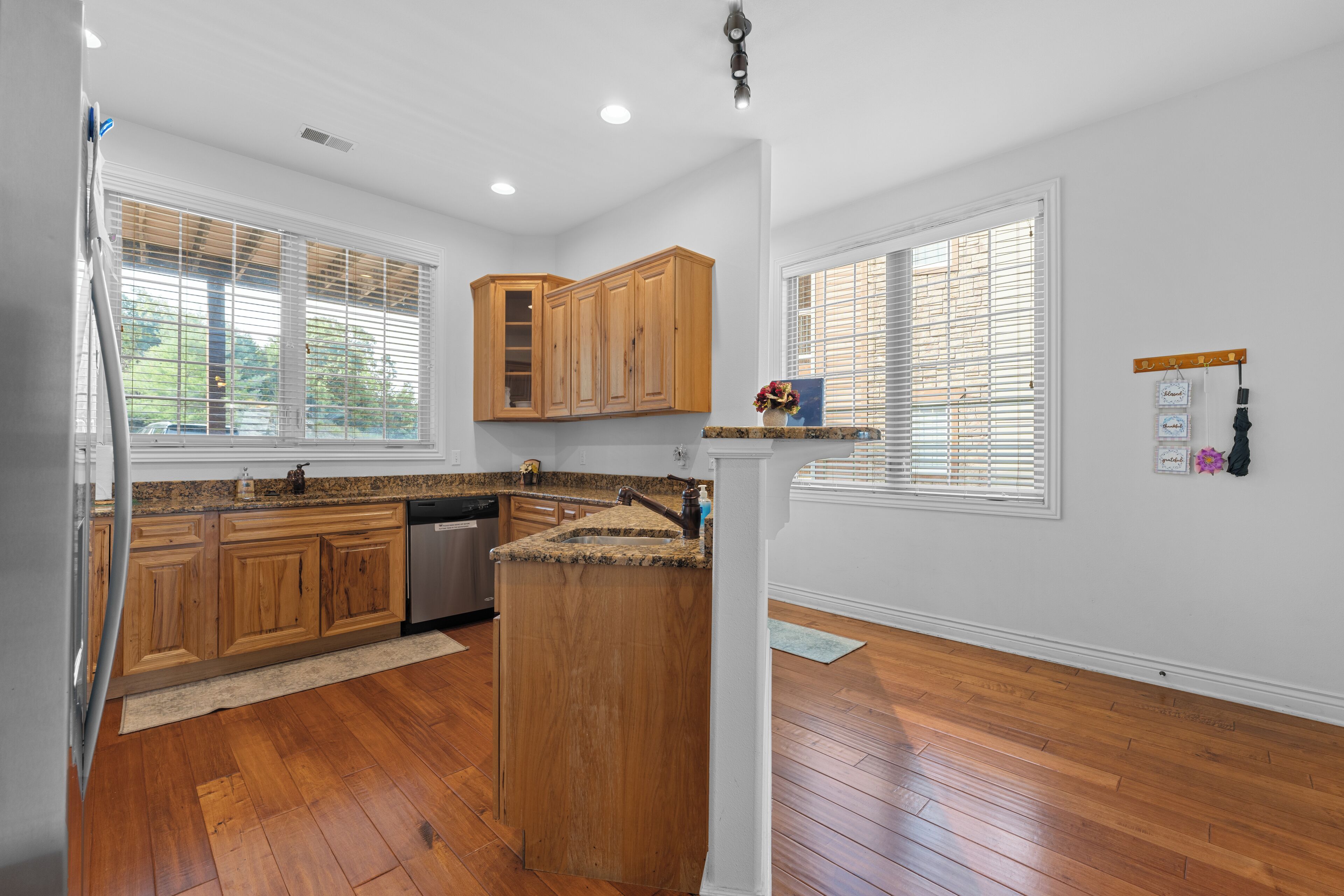 A kitchen with wooden cabinets, granite countertops, and a central island.