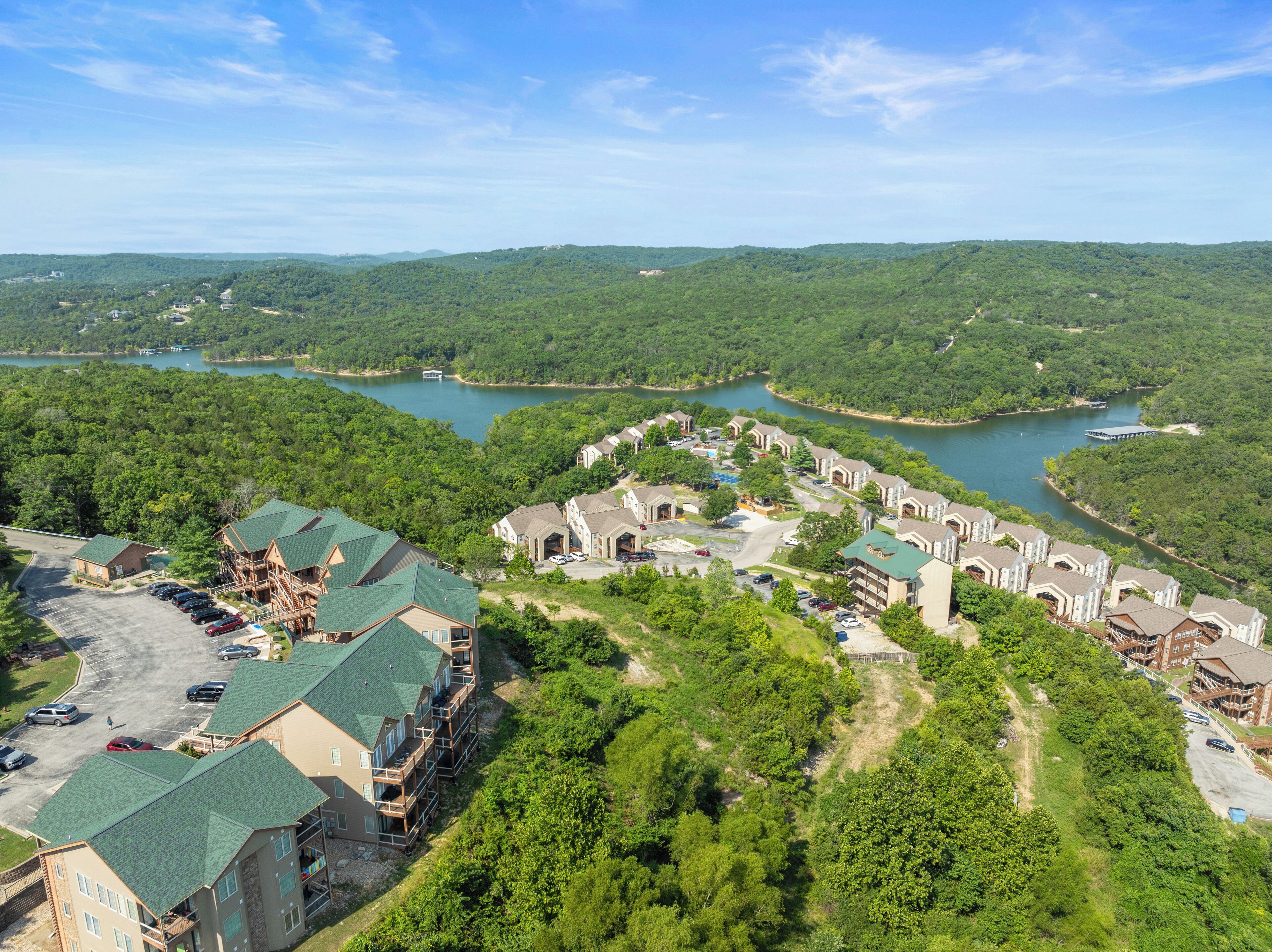 A resort with multiple buildings, a parking lot, and a river.