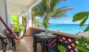 Ein Balkon mit Esstisch, Stühlen, einer Hängematte und Kübelpflanzen.