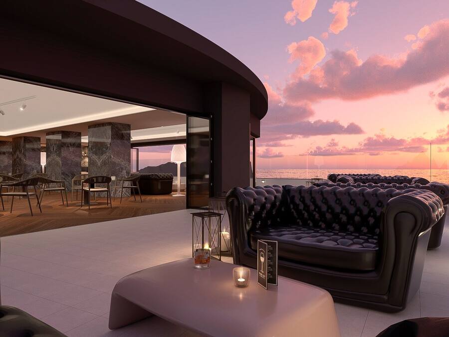 Un espacio de estar moderno al aire libre con vistas a la puesta de sol sobre el océano.