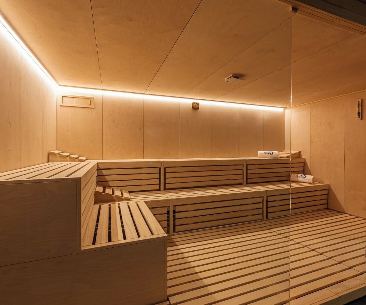 Una sauna con bancos de madera y suelo inclinado.