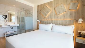 Una habitación de hotel moderna con una cama grande, cabina de ducha de vidrio, pared decorativa de madera y teléfono junto a la cama.