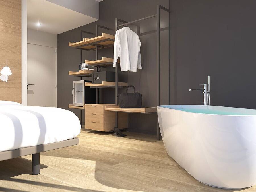A modern bedroom with a bed, a desk, a wardrobe, and a large bathtub.