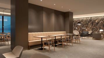 A modern interior with a sofa, tables, and chairs arranged for dining.