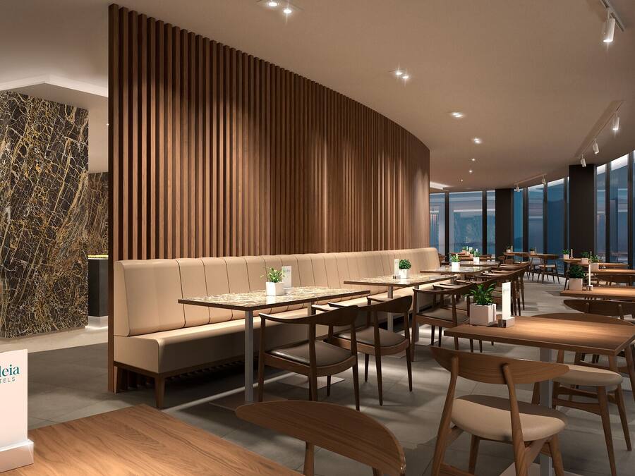 Un hall d’hôtel moderne doté d’un espace salon central, de lambris en bois et d’un comptoir d’accueil en marbre.