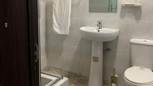 Um banheiro com banheira, pia, vaso sanitário e espelho.