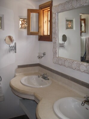 Une salle de bain avec deux lavabos, un miroir et un porte-serviettes.