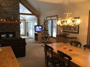 Cozy living area with a fireplace, dining table, and TV, offering a comfortable space to relax and enjoy the view.