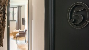 Un pasillo que conduce a una habitación con una puerta oscura marcada con el número 5.